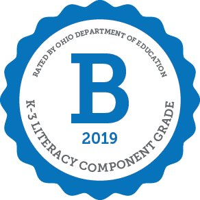 Seal with a large 'B' for K-3 literacy component grade.